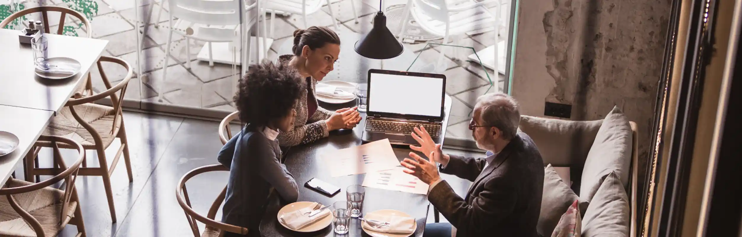 Decorative image of people sitting around a desk, discussing