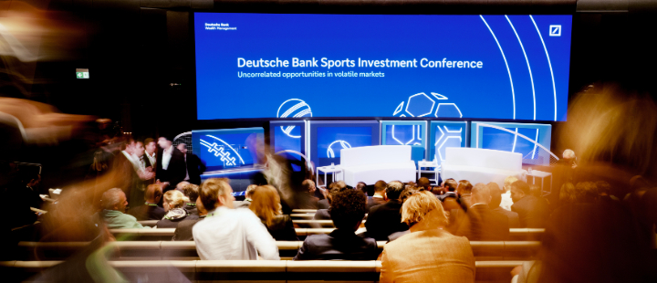 Audience watching speakers at a sports investment conference.