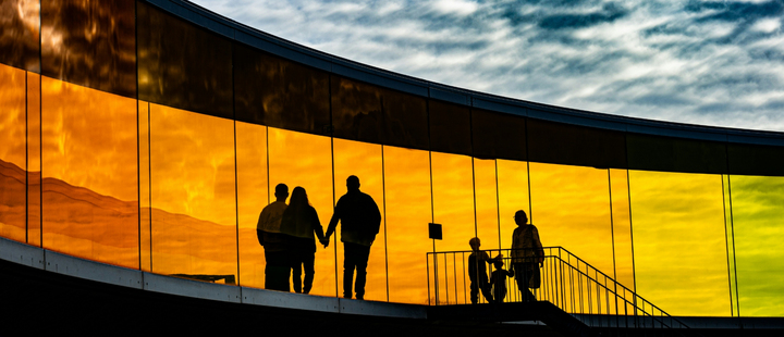 Family silhouette on bridge against sky