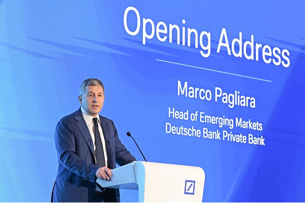 Speaker delivers opening address at Deutsche Bank event podium.