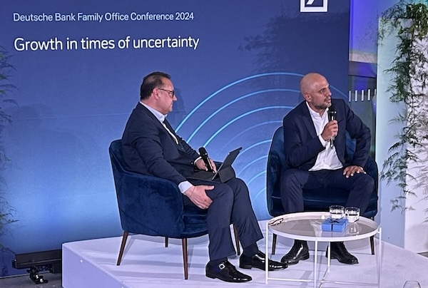 Two speakers in discussion at a Deutsche Bank event.