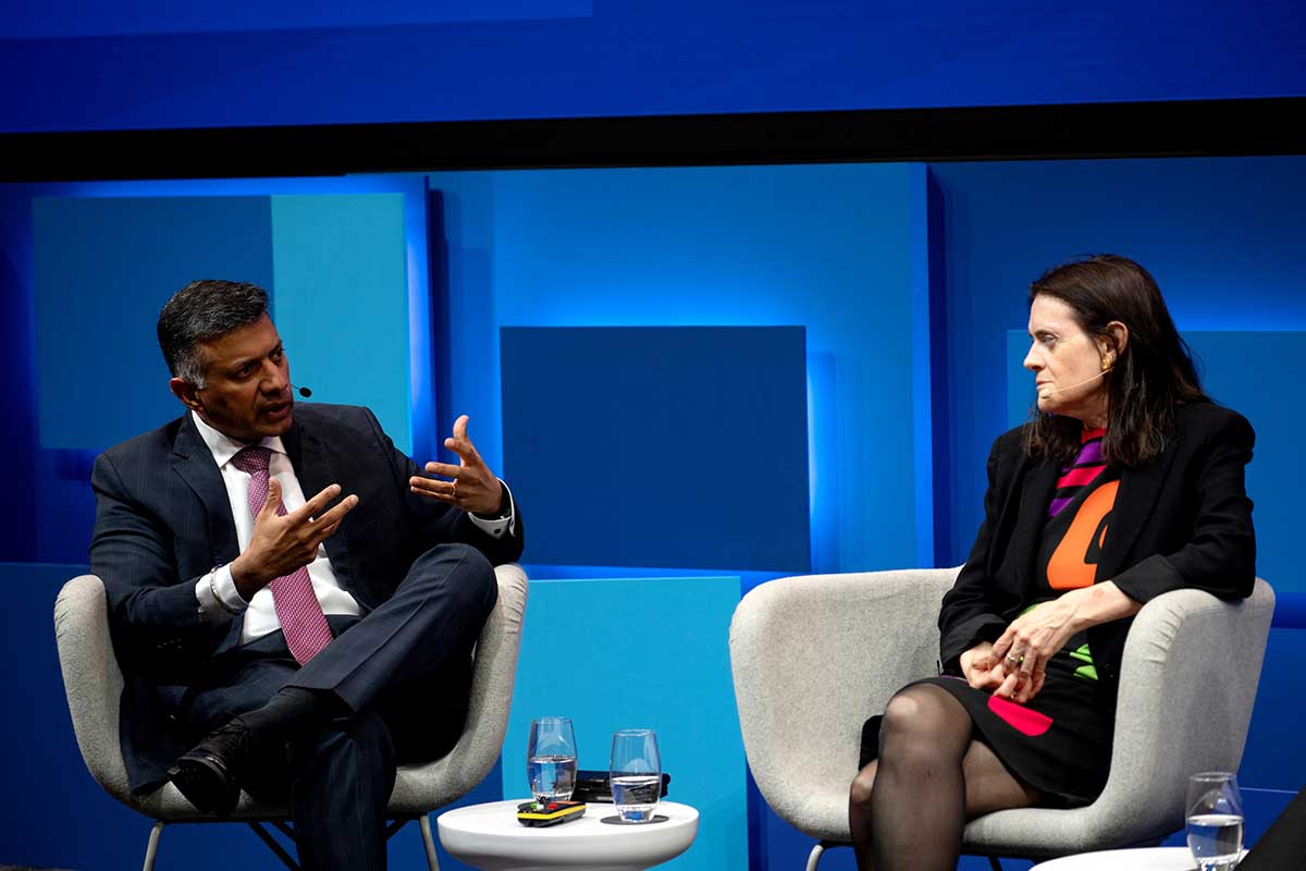 Panel discussion at Deutsche Bank event with two speakers seated on stage.